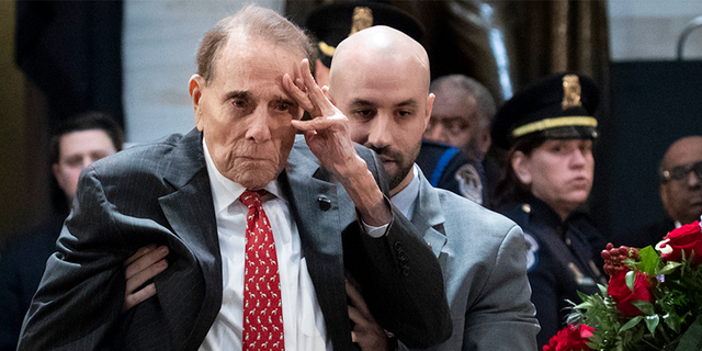 Former Senator Bob Dole stands to greet the late former President George HW Bush's coffin, which lies in the U.S. Capitol in Washington, DC, in the state on December 4, 2018.  (Photo by Drew Angerer / Getty Images)