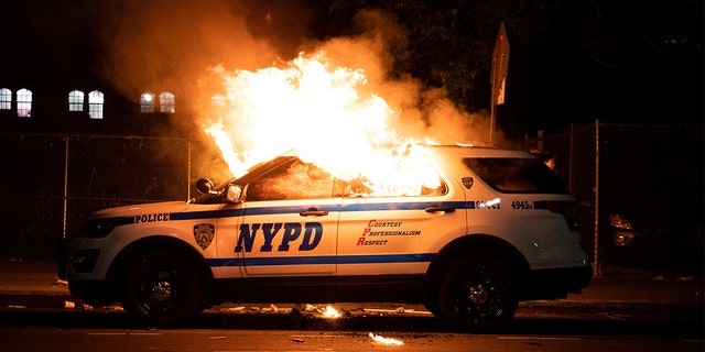 A NYPD police car is set on fire as protesters clash with police during a march against the death in Minneapolis police custody of George Floyd, in the Brooklyn borough of New York City, US, May 30, 2020. Picture taken May 30, 2020.